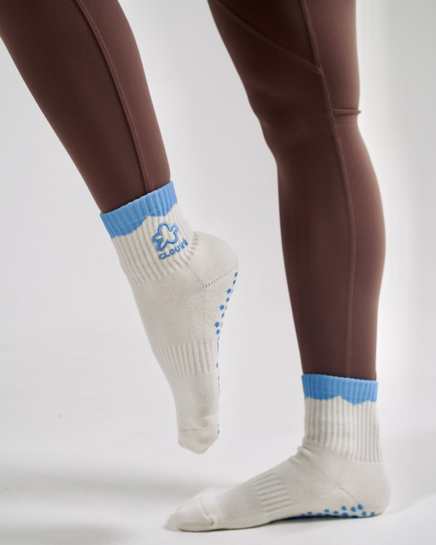 White socks with blue accents worn by a person on a plain background